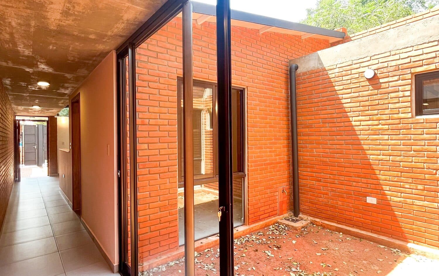 El pasillo vidriado que da al patio interno de ladrillo visto